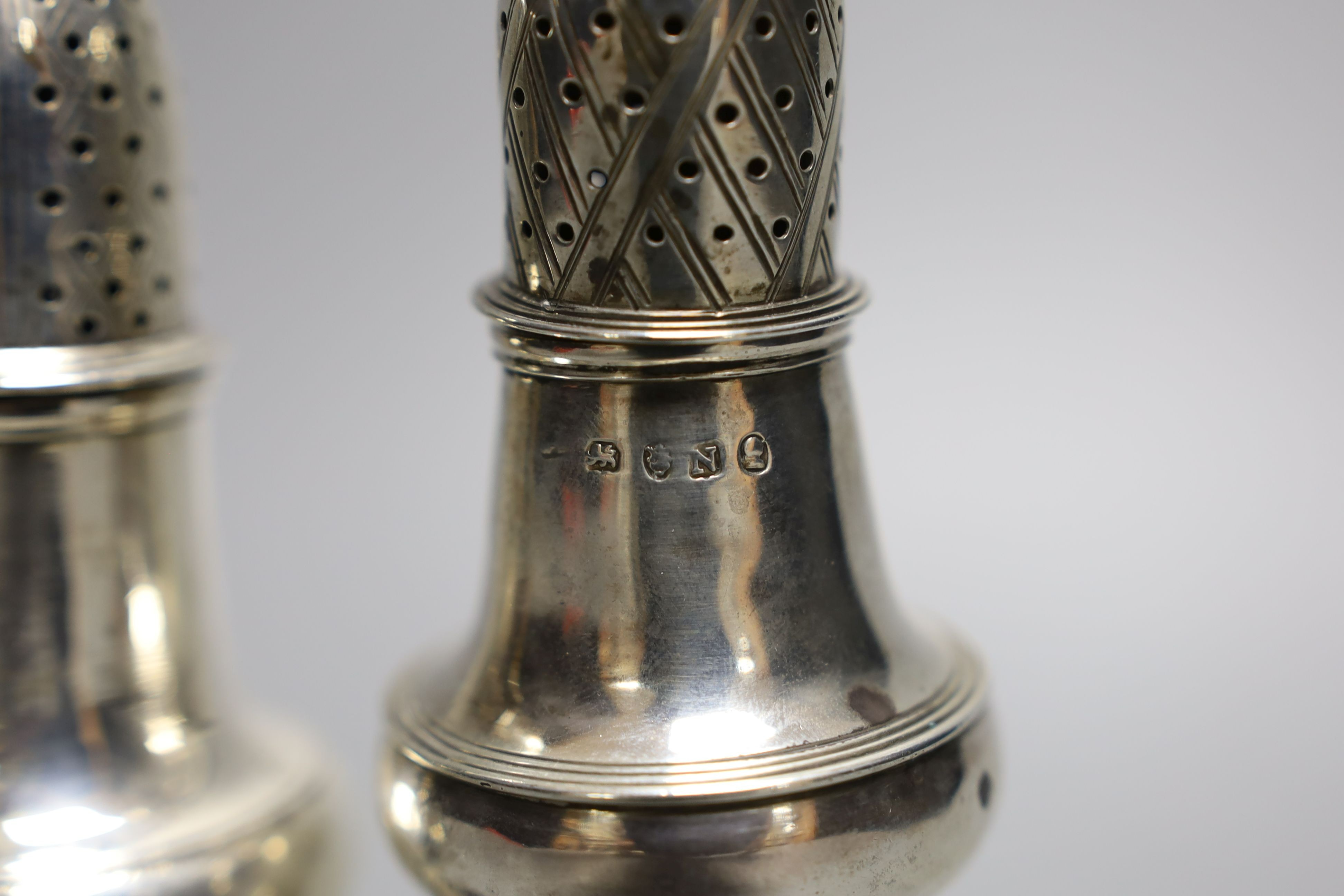 A George III silver pepperette, London, 1808, 13.9cm and one earlier silver pepperette with spiral finial, London, 1780.